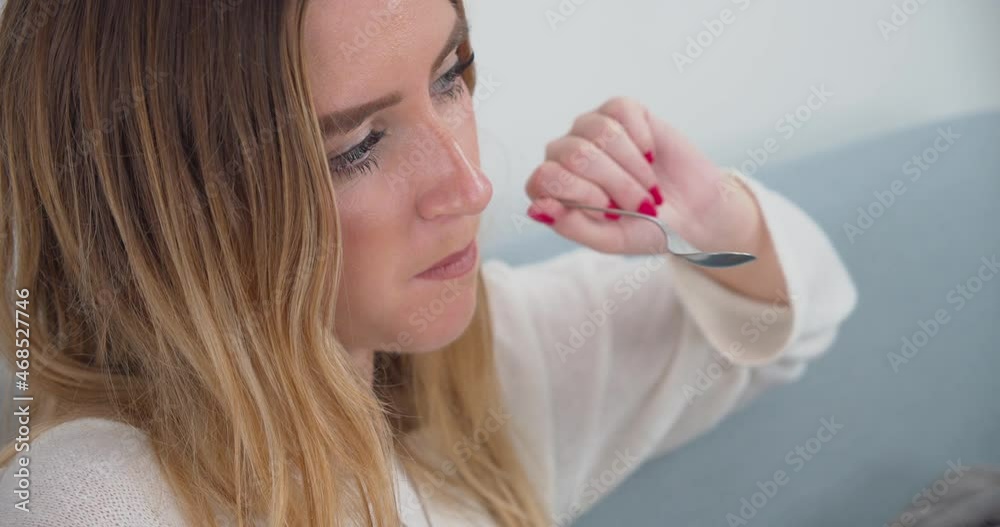 Beautiful sad young lady looking away from camera and eating slowly. Static. Beautiful sad young lady looking away from camera and eating slowly. Static.