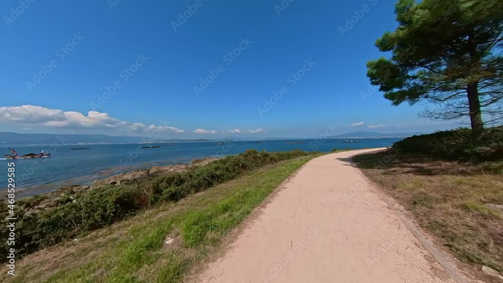 Travelling along a narrow dirt road with sea and trees on a beautiful sunny day on the island of Arousa, Galicia, Spain. Travelling along a narrow dirt road with sea and trees on a beautiful sunny day on the island of Arousa, Galicia, Spain.