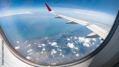 Wing of an airplane flying above the ocean. The view from an airplane window. Photo applied to tourism operators.