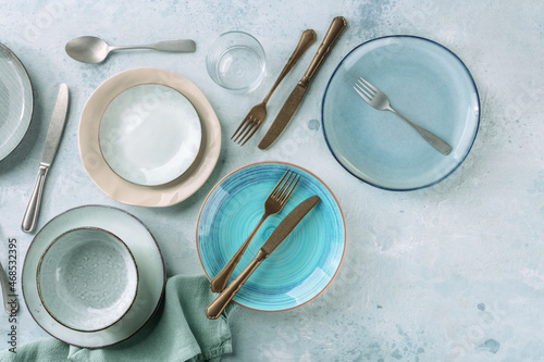 Modern tableware set with cutlery and a vibrant blue plate, overhead flat lay shot with copy space photo