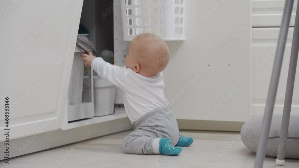 Kitchen safety for kids, baby boy exploring all around the house, toddler playing with pull out trash can under kitchen sink. High quality 4k footage Kitchen safety for kids, baby boy exploring all around the house, toddler playing with pull out trash can under kitchen sink. High quality 4k footage
