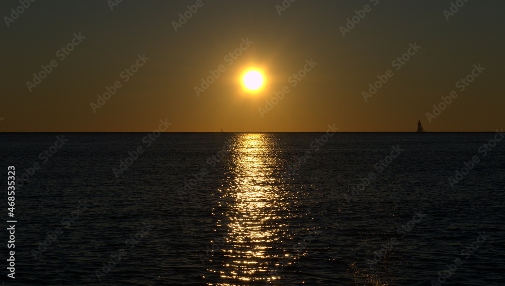 Orange sunset on the sea. The sun is reflected in the water