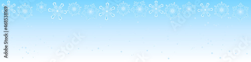 horizontal banner of gentle blue color with snow and beautiful large snowflakes 