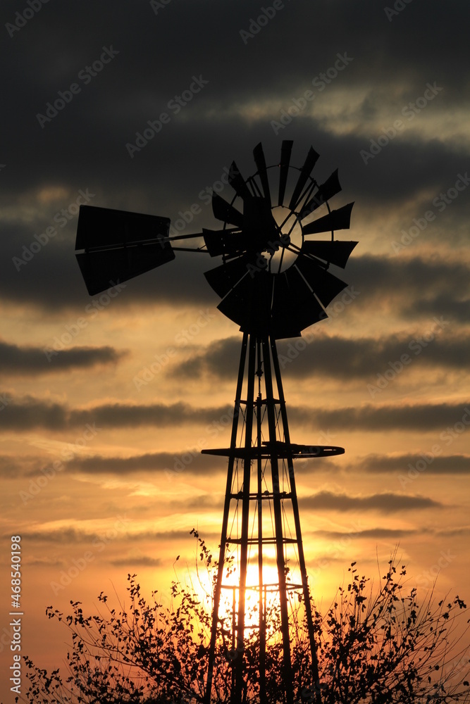 windmill at sunset with Strato Cumulus Clouds north of Hutchinson Kansas USA out in the country. windmill at sunset with Strato Cumulus Clouds north of Hutchinson Kansas USA out in the country.