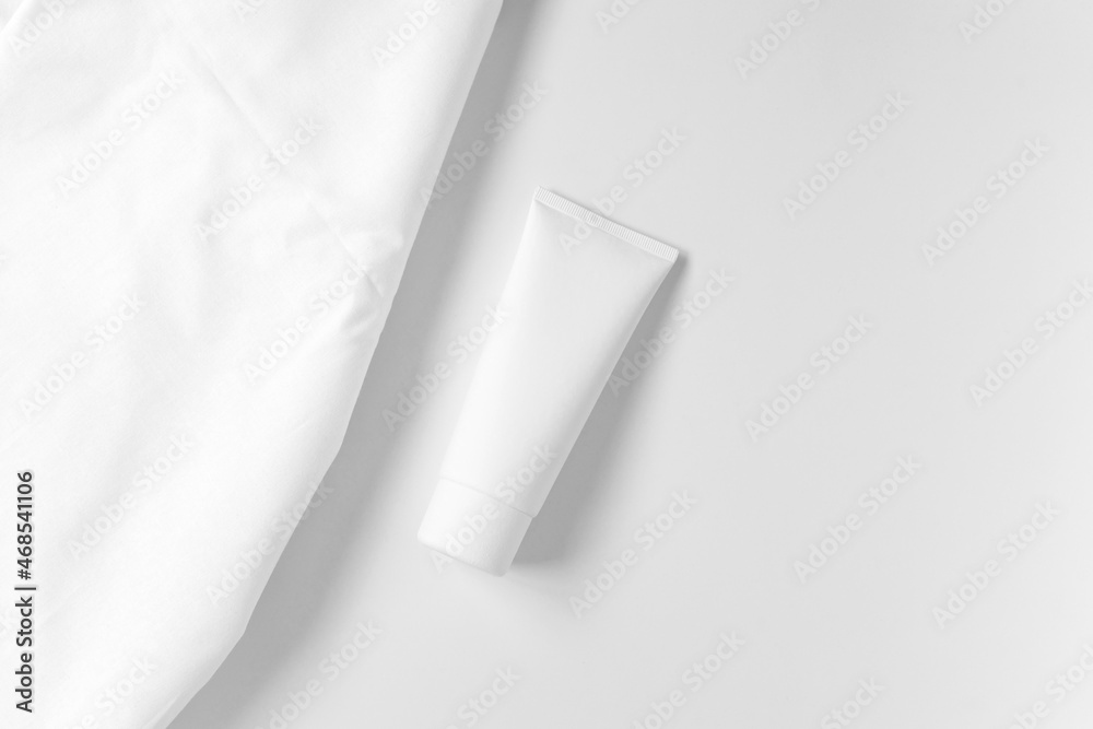 Cream Bottle Mockup. Cosmetic Bottle Mock Up on white background near white cotton textile. Fabric mockup. Blank White Glossy Tube Cream Bottle Mockup. Cosmetic Bottle Mock Up on white background near white cotton textile. Fabric mockup. Blank White Glossy Tube