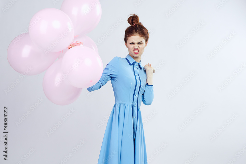 Fototapeta premium cheerful woman in a blue dress pink balloons holiday birthday