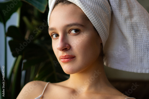 Close-up portrait of a beautiful young caucasian woman with her hair covered in a towel.