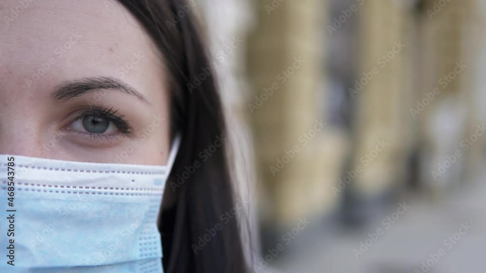 Sad girl in a medical mask in a big city. In the cities of the world, Covid-19 quarantine, people on self-isolation. Sad girl in a medical mask in a big city. In the cities of the world, Covid-19 quarantine, people on self-isolation.