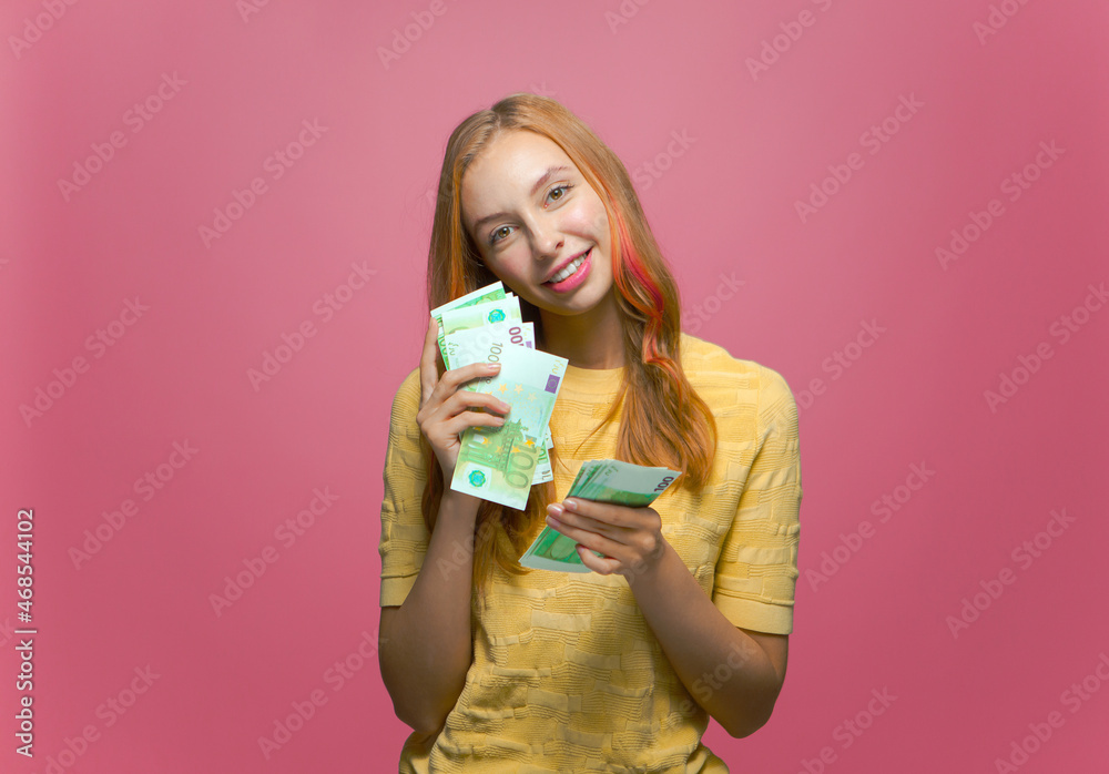 Smiling young girl count money, cash in hands enjoying lottery win, financial reward, salary on pink studio background Smiling young girl count money, cash in hands enjoying lottery win, financial reward, salary on pink studio background