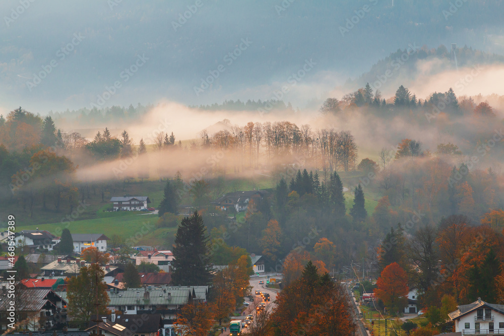 Foggy morning the cozy Berchtesgaden town,  typical mountain scenery in the background of the famous Watzmann Mountains in beautiful autumn colors