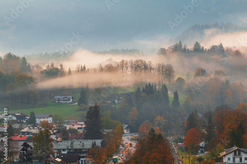 Foggy morning the cozy Berchtesgaden town, typical mountain scenery in the background of the famous Watzmann Mountains in beautiful autumn colors