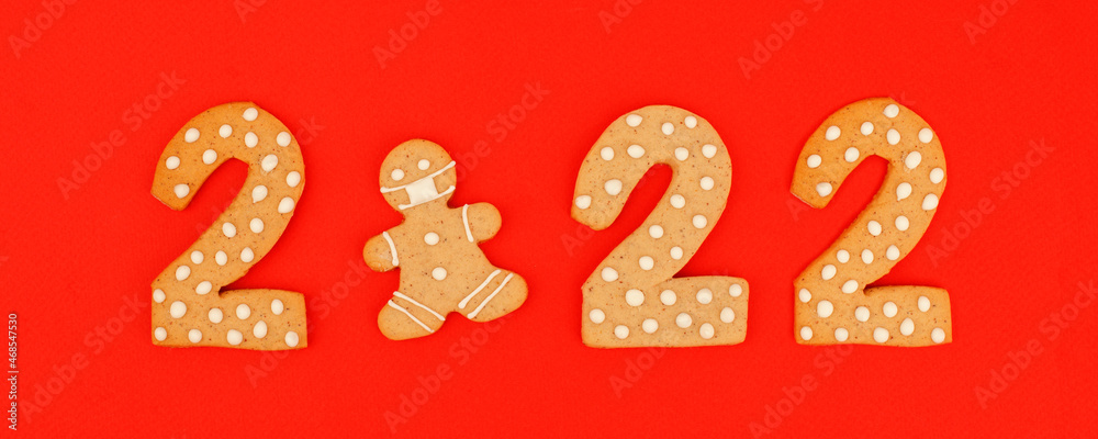 Happy New Year's, Christmas set of numbers 2022, gingerbread man in face mask from ginger biscuits glazed sugar icing decoration on red background, seasonal pandemic winter holiday banner Happy New Year's, Christmas set of numbers 2022, gingerbread man in face mask from ginger biscuits glazed sugar icing decoration on red background, seasonal pandemic winter holiday banner