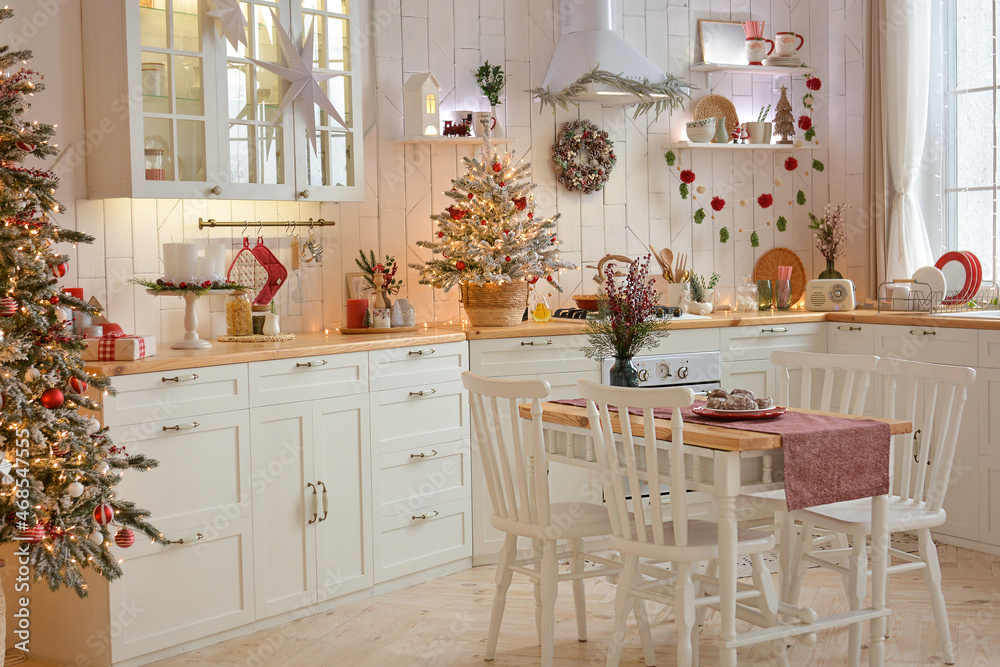Interior of a light white ?hristmas kitchen with red decor elements in the Scandinavian style. Christmas decorations. Breakfast