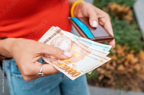 The woman took out Armenian dram banknotes and holds them in her hands, close-up. Cash exchange rates and money inflation concept