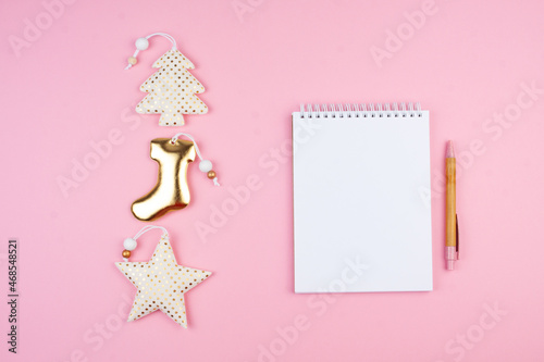 Notepad and pen on pink background. Christmas Planning Concept for 2022.