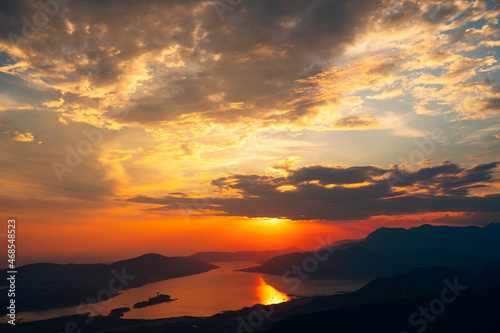 Orange clouds in the rays of the setting sun over the bay. View from Mount Lovcen
