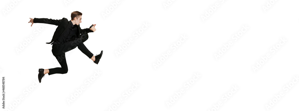 Young man in black business suit dancing isolated on white background. Art, motion, action, flexibility, inspiration concept. - obrazy, fototapety, plakaty 