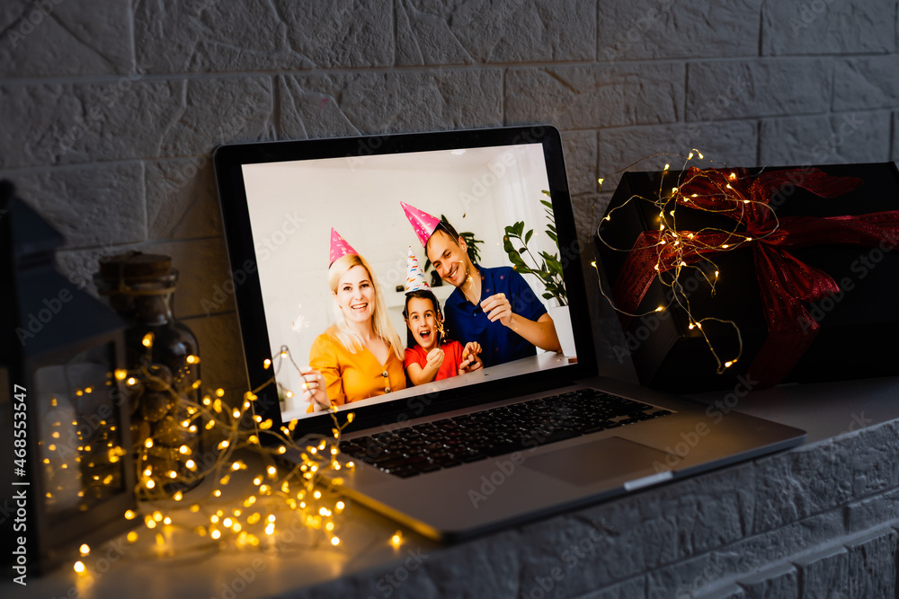 Image of open laptop family and christmas on wooden table in front of christmas tree background Image of open laptop family and christmas on wooden table in front of christmas tree background