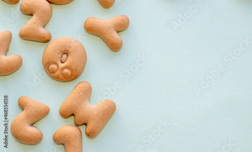 little cookies, numbers and letters shapes on blue color paper background, poured chaotic. space for text. set of sweet biscuits.back to school concept,learning and education