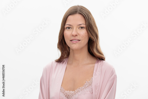 Pretty young woman in beautiful light silk robe on white background