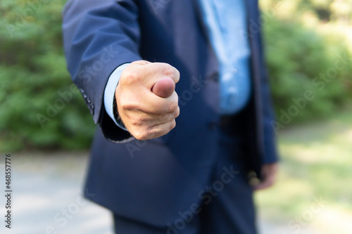 a gesture signifying refusal of any request. businessman holds fig sign close up - hand gesture photo