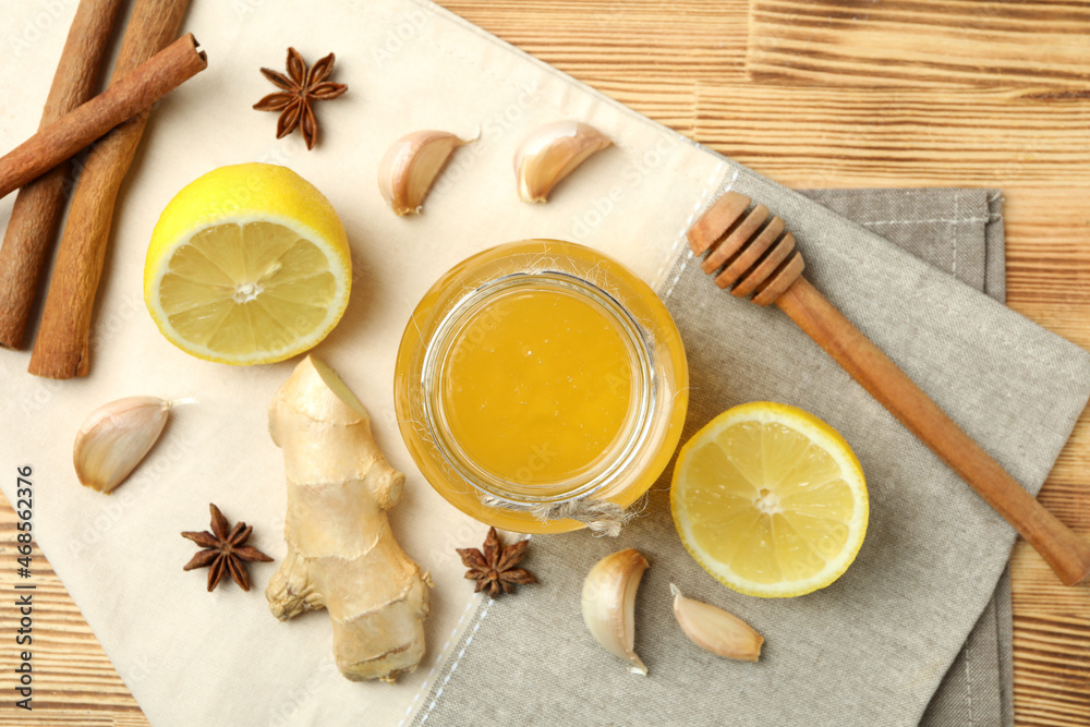 Concept of treatment colds with honey and garlic on wooden background Concept of treatment colds with honey and garlic on wooden background