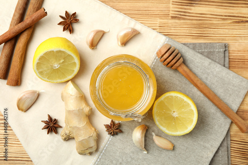 Concept of treatment colds with honey and garlic on wooden background