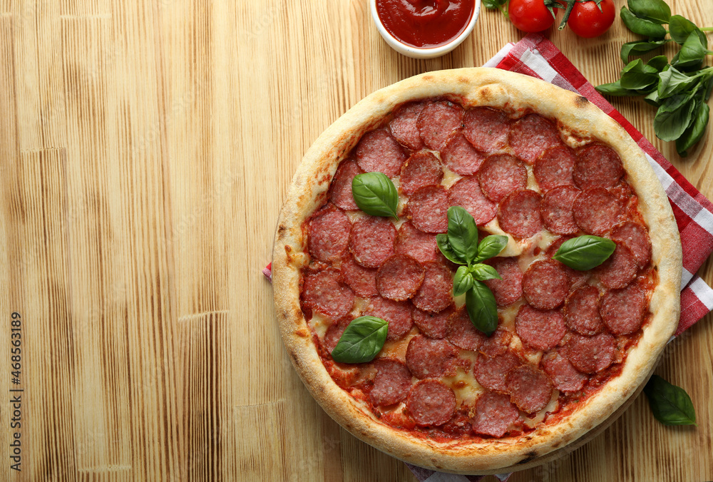 Concept of tasty food with Salami pizza on wooden background Concept of tasty food with Salami pizza on wooden background