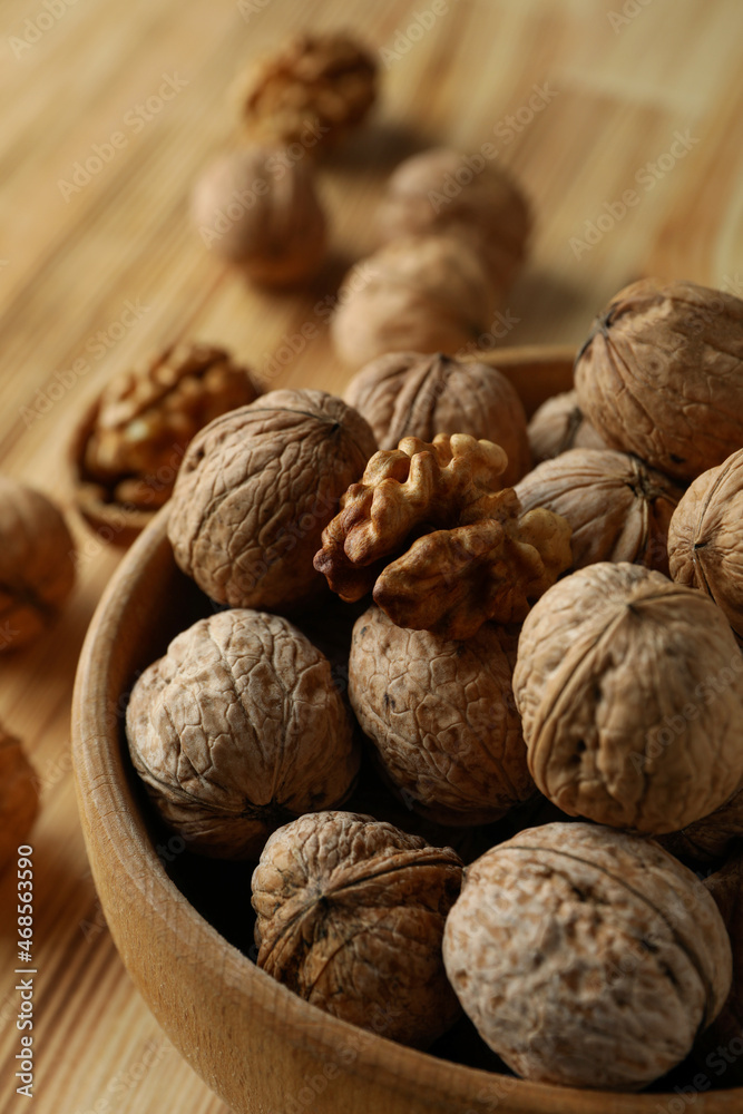 Walnuts in wooden bowl on wooden background Walnuts in wooden bowl on wooden background