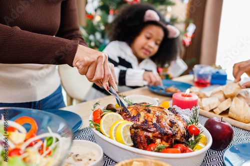 Happy family are having dinner at home. Celebration holiday and togetherness near Christmas tree. African American family. Merry Christmas.