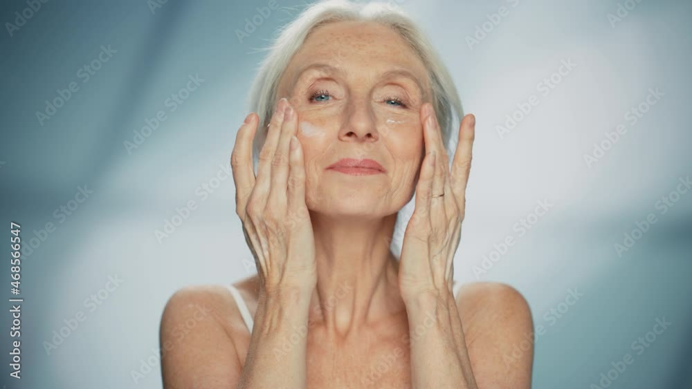 Portrait of Beautiful Senior Woman Looking Afar then Turning Her Gaze Looking at Camera and Smiling. Elderly Beauty. Graceful of Old Age Concept for Skincare, Cosmetics Product. Isolated Background