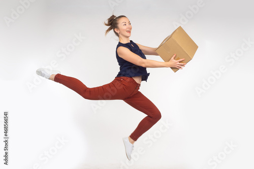 Woman with box. She is happy to receive package. Delivery box symbol. Satisfied girl on light background. Online store buyer concept. Happy woman with parcel. Online store customer jumping for joy