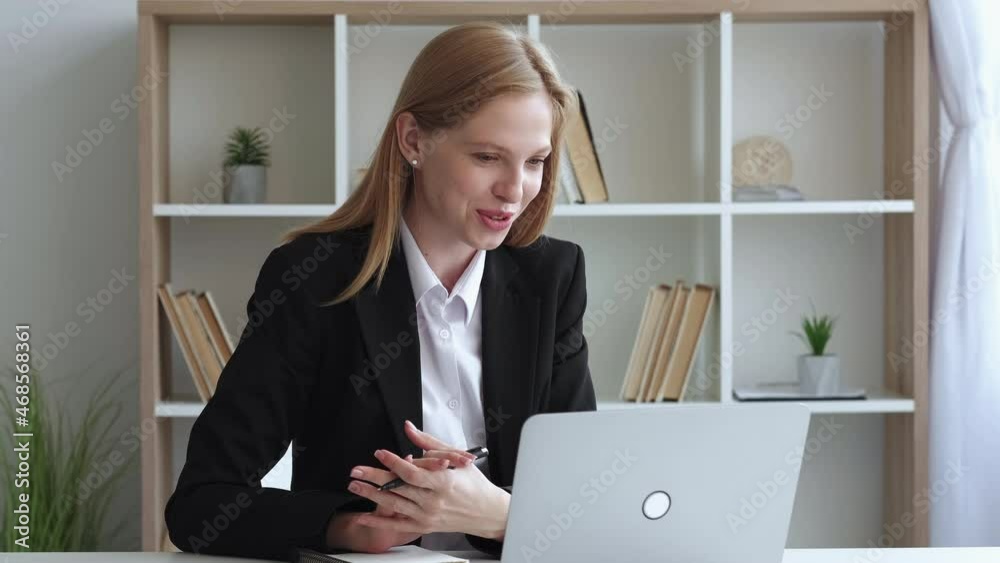 Online interview. Female speaker. Video meeting. Inspired elegant woman having web conference on laptop in light room interior. Online interview. Female speaker. Video meeting. Inspired elegant woman having web conference on laptop in light room interior.