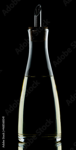 Olive oil dispenser isolated on black low key