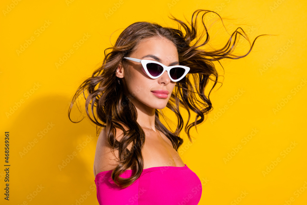 Profile side view portrait of stunning serious wavy-haired girl hair flying isolated over vibrant yellow color background