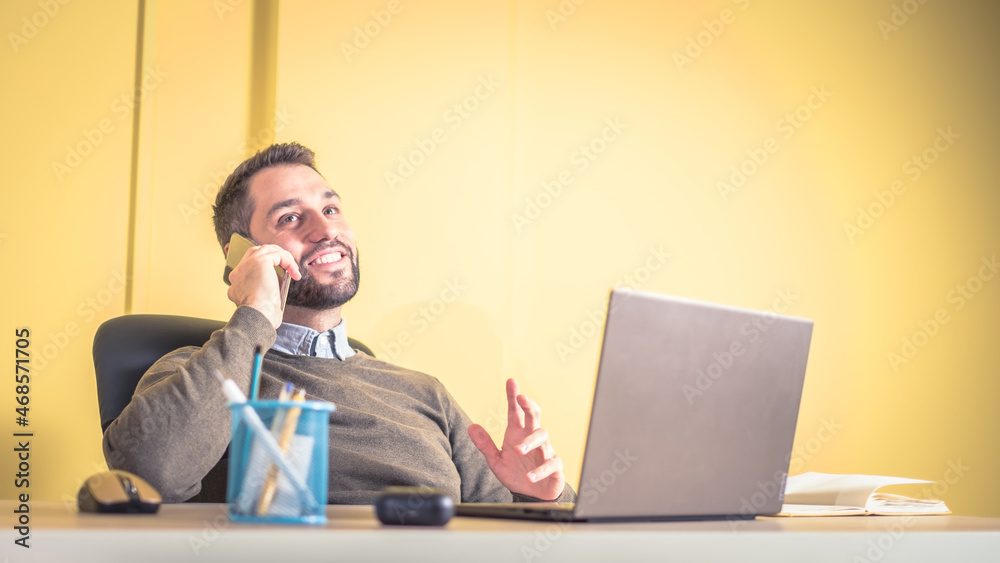 businessman sitting at his desk and speaking on the phone businessman sitting at his desk and speaking on the phone