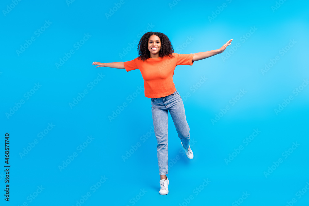 Full size photo of young african excited woman happy positive smile hands plane fly isolated over blue color background