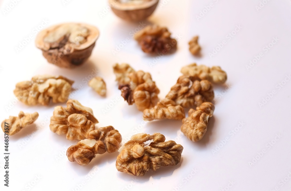 Whole and cracked walnuts on white background, selective focus Whole and cracked walnuts on white background, selective focus