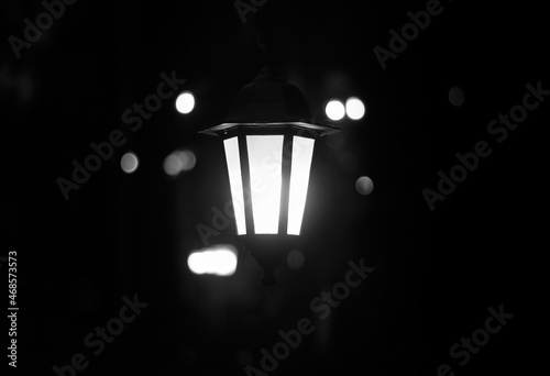 Lantern in the dark. Burning lantern in the dark. Electric lamp. Black and white photo