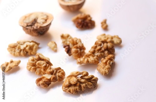 Whole and cracked walnuts on white background, selective focus