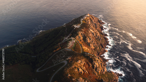 Cape Finisterre Lighthouse the end of the earth famous tourist destination in Galicia northern Spain region, aerial drone footage at sunset photo