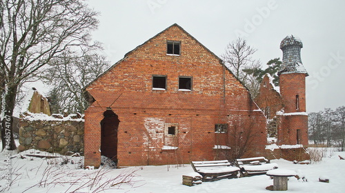 The ruins of the red brick distillery of the former Kurmale manor with an interesting tower on a winter day, Latvia. photo