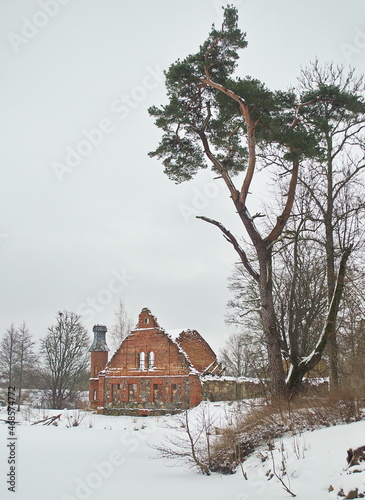 The ruins of the red brick distillery of the former Kurmale manor with an interesting tower on a winter day, Latvia. photo