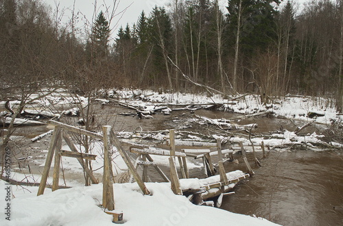 Old broken wooden bridge by the river Riezupe, Latvia.