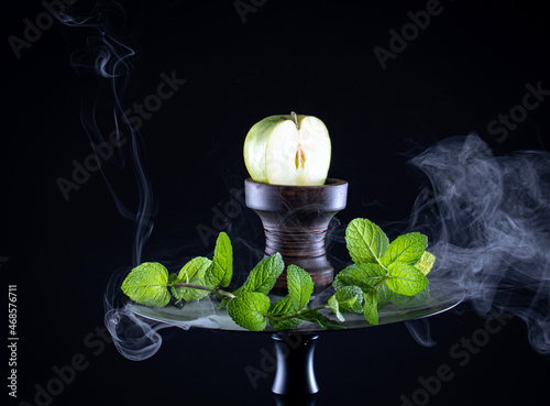 fruit hookah with tobacco, apple, mint and smoke on black background