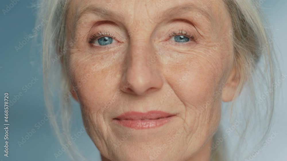 Close-up Portrait of Beautiful Senior Woman Turning, Looking at Camera and Smiling Wonderfully. Gorgeous Looking Elderly Grandmother with Natural Beauty of Grey Hair, Blue Eyes and Cheerful Worldview