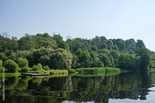 country forest lake in summer with deep blue water with reflections