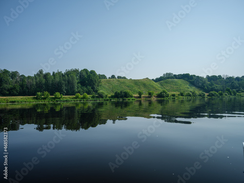 country forest lake in summer with deep blue water with reflections
