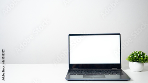 Laptop blank white screen on the table copy space