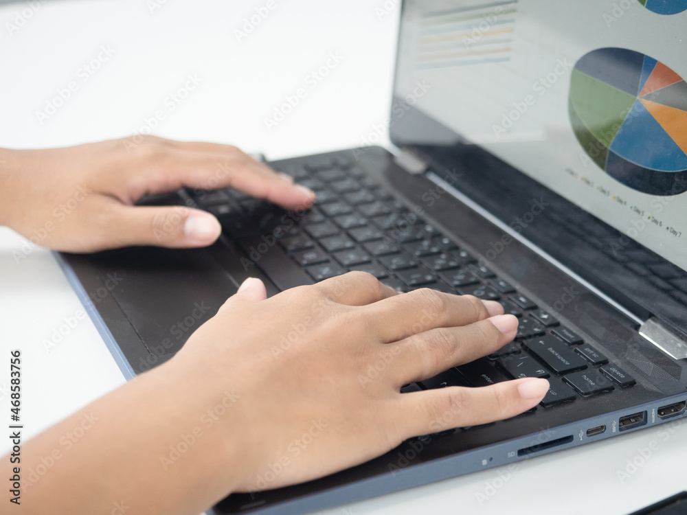 Close up hand using laptop charts graphs business at screen on the table Close up hand using laptop charts graphs business at screen on the table